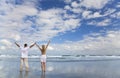 Man and Woman Celebrating Arms Raised On A Beach