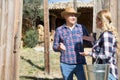 Man and woman chatting near wooden gates