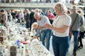 Man and woman choosing interesting souvenirs at traditional flea market