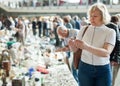 Man and woman choosing interesting souvenirs at traditional flea market