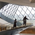 Man and woman climb spiral staircase at The Louvre Paris