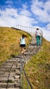 Man and woman are climbing to the mountaintop in the sunny day.