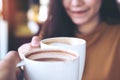 Man and woman clink coffee mugs in cafe