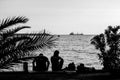 Man and woman on coastline in the port on end at of the end of the day - grayscale, grained Royalty Free Stock Photo