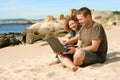 Man and woman with computer at beach Royalty Free Stock Photo