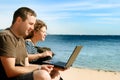 Man and woman with computer at beach Royalty Free Stock Photo