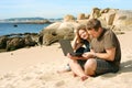 Man and woman with computer at beach Royalty Free Stock Photo