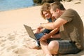 Man and woman with computer at beach Royalty Free Stock Photo