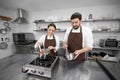 Man and woman confectioners prepare dessert together in a professional kitchen, cook syrup and cream