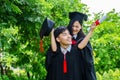 A man and woman couple dressed in black graduation gown or graduates with congratulations with graduation hats is standing, Royalty Free Stock Photo