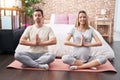 Man and woman couple expecting belly doing yoga exercise at bedroom Royalty Free Stock Photo