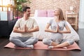 Man and woman couple expecting belly doing yoga exercise at bedroom Royalty Free Stock Photo