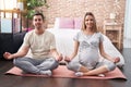 Man and woman couple expecting belly doing yoga exercise at bedroom Royalty Free Stock Photo