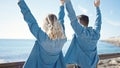 Man and woman couple with hands raised up backwards at seaside Royalty Free Stock Photo