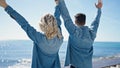 Man and woman couple with hands raised up backwards at seaside Royalty Free Stock Photo