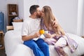 Man and woman couple kissing and hugging each other drinking coffee at bedroom Royalty Free Stock Photo