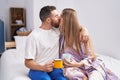 Man and woman couple kissing and hugging each other drinking coffee at bedroom Royalty Free Stock Photo