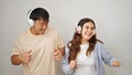 Man and woman couple listening to music dancing together over isolated white background Royalty Free Stock Photo