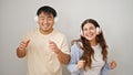 Man and woman couple listening to music dancing together over isolated white background Royalty Free Stock Photo