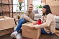 Man and woman couple packing fragile cardboard box at new home