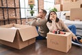 Man and woman couple packing fragile cardboard box at new home