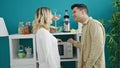 Man and woman couple preparing food with microwave at dinning room Royalty Free Stock Photo