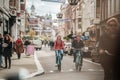 Man and woman couple riding bicycle along narrow shopping street in Amsterdam, Netherlands pushbikes mixing with pedestrians