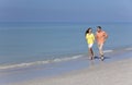 Man & Woman Couple Running on An Empty Beach Royalty Free Stock Photo
