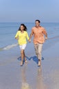 Man & Woman Couple Running on An Empty Beach Royalty Free Stock Photo