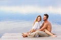 Man and woman couple sitting on a jetty at a seaside Royalty Free Stock Photo