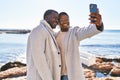 Man and woman couple standing together make selfie by the smartphone at seaside