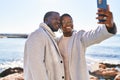 Man and woman couple standing together make selfie by the smartphone at seaside