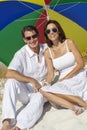 Man & Woman Couple Under Multi Colored Umbrella on Beach Royalty Free Stock Photo