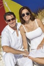 Man & Woman Couple Under Multi Colored Umbrella on Beach Royalty Free Stock Photo