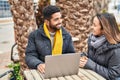 Man and woman couple using laptop drinking coffee at coffee shop terrace Royalty Free Stock Photo