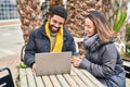 Man and woman couple using laptop drinking coffee at coffee shop terrace Royalty Free Stock Photo