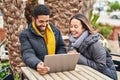 Man and woman couple using laptop drinking coffee at coffee shop terrace Royalty Free Stock Photo