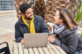 Man and woman couple using laptop drinking coffee at coffee shop terrace Royalty Free Stock Photo