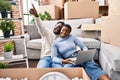 Man and woman couple using laptop sitting on floor at new home Royalty Free Stock Photo