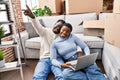 Man and woman couple using laptop sitting on floor at new home Royalty Free Stock Photo