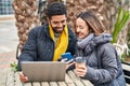 Man and woman couple using laptop and smartphone drinking coffee at coffee shop terrace Royalty Free Stock Photo