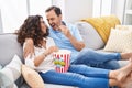 Man and woman couple watching movie sitting on sofa at home Royalty Free Stock Photo