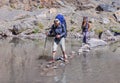 Man and woman crossing mountain river Royalty Free Stock Photo