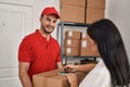 Man and woman deliveryman and worker holding package signing on smartphone at storehouse
