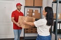 Man and woman deliveryman and worker holding package at storehouse