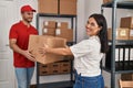 Man and woman deliveryman and worker holding package at storehouse