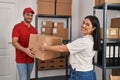 Man and woman deliveryman and worker holding package at storehouse