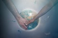 A man and a woman of different races holding hands on the background of the globe of the planet Earth. The concept of Royalty Free Stock Photo