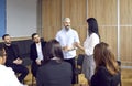 Man and woman discussing new project on office meeting with colleagues during working day.