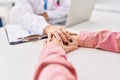 Man and woman doctor and patient having medical consultation with hands together at clinic Royalty Free Stock Photo